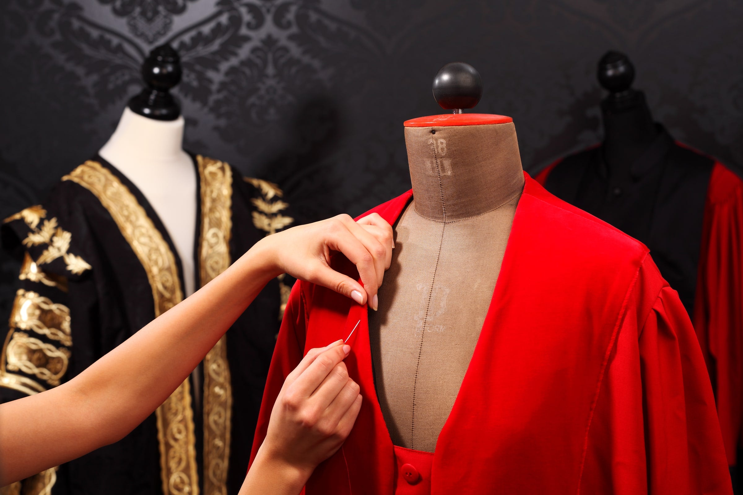 A crimson robe being fitted in the Manufaktur Bavaria atelier — handwork, made to measure