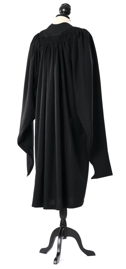 Cambridge master's gown in black, back view with gathered shoulders and hanging sleeves