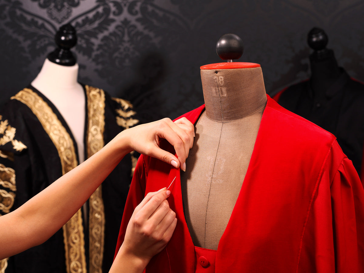 A crimson robe being fitted in the Manufaktur Bavaria atelier — handwork, made to measure