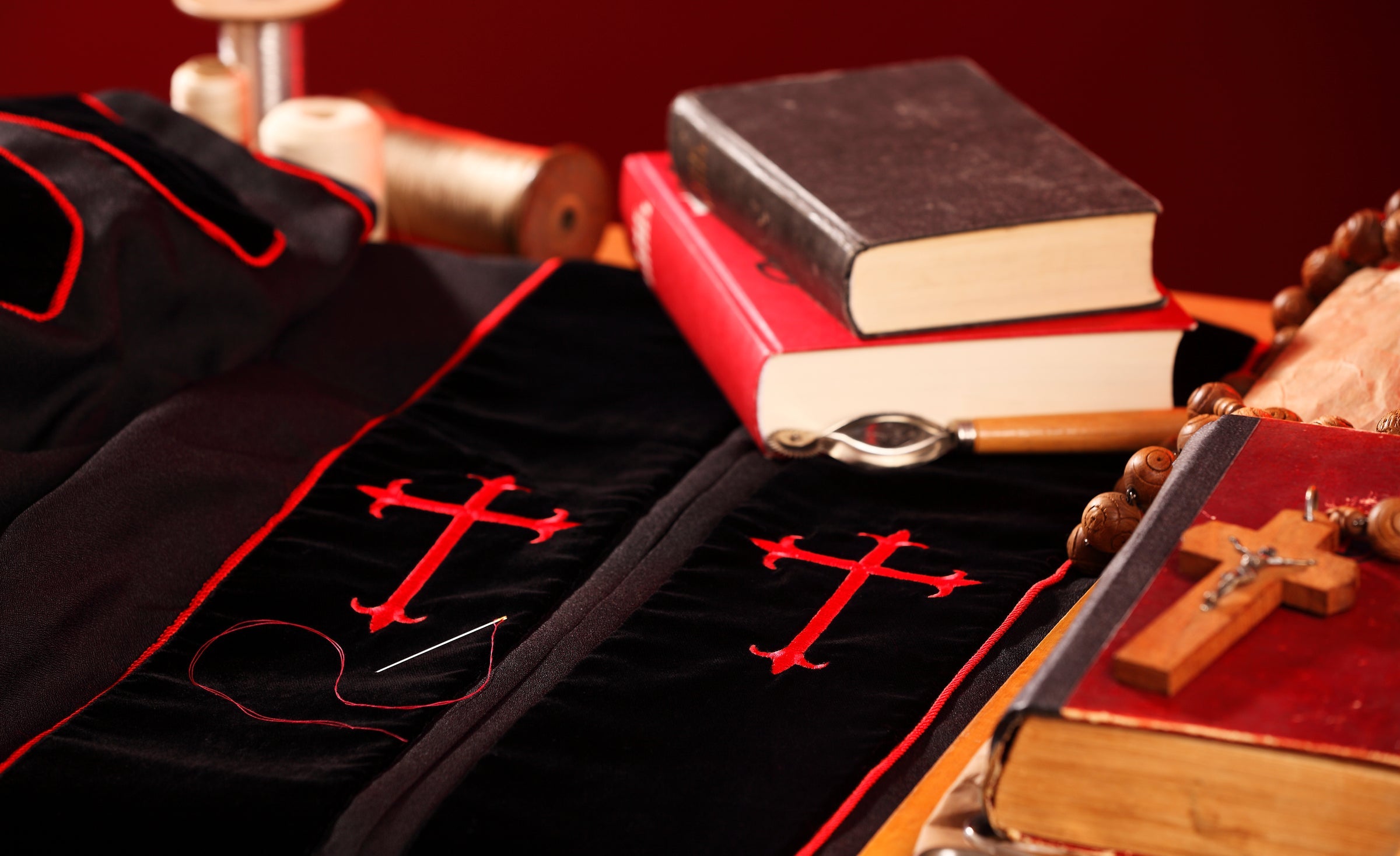Clerical vestment with red cross embroidery, Bible and rosary