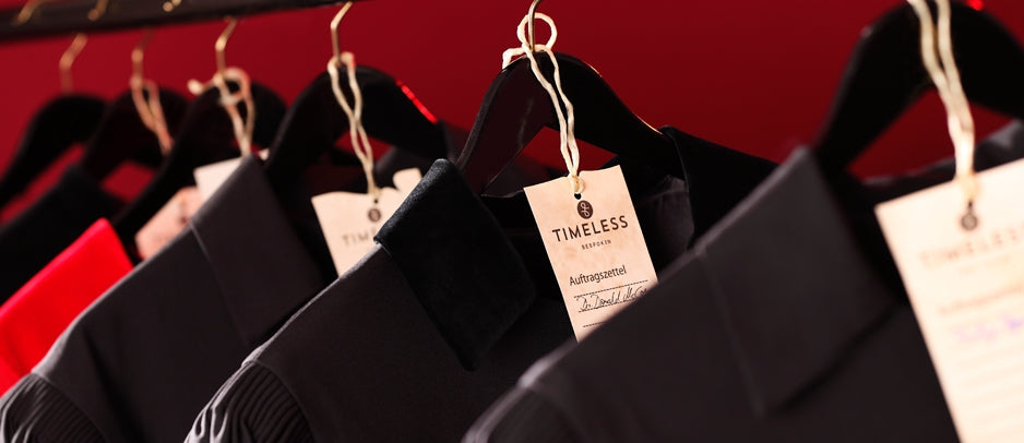 Bespoke robes with manufactory labels on hangers in the atelier