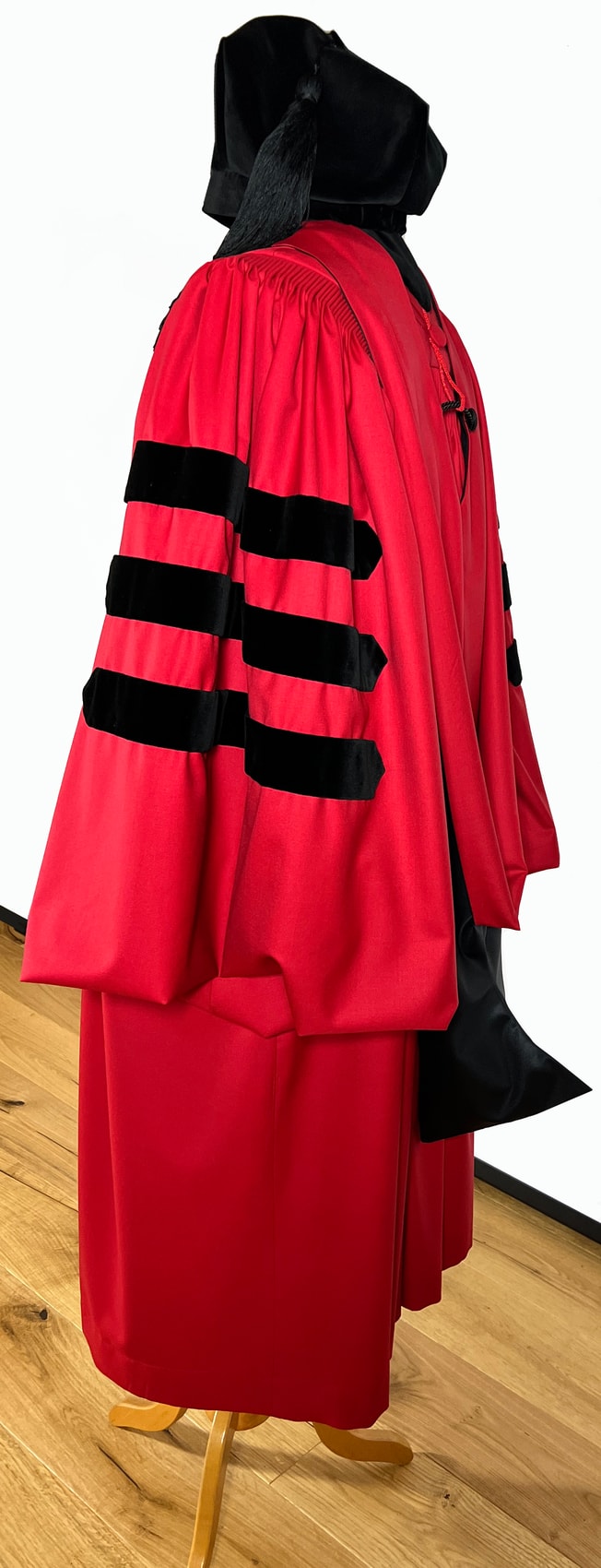 Harvard doctoral robe in crimson with the three black velvet bars on the sleeve